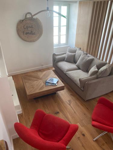 un salon avec un canapé et des chaises rouges dans l'établissement Maison de ville, à La Flotte