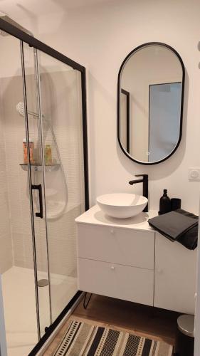 une salle de bain avec un lavabo et un miroir dans l'établissement Maison de ville, à La Flotte
