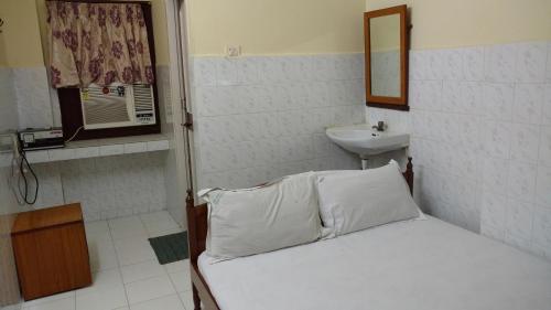 a small bedroom with a bed and a sink at Thangam balaji Guest House -Near US Consulate and VFS Global application in Chennai