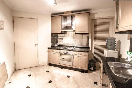 a kitchen with wooden cabinets and a stove top oven at Batavia Apartment ST in Jakarta