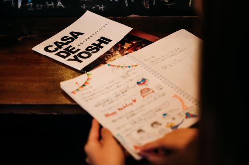 a person is reading a book on a table at CASA DE YOSHi 一棟貸し in Yamagata
