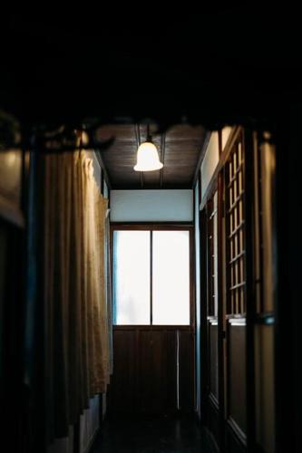 a dark hallway with a window and a light at CASA DE YOSHi 一棟貸し in Yamagata