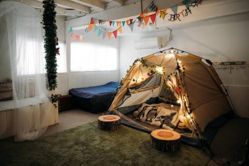 una camera con tenda e sgabelli. di CASA DE YOSHi 一棟貸し a Yamagata