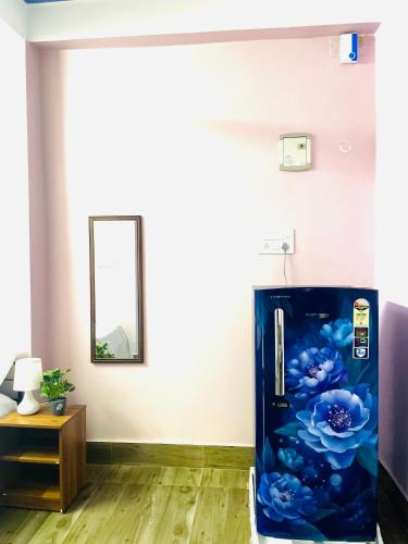 a blue refrigerator in a room with a mirror at Renade Leisure Stay in Agartala
