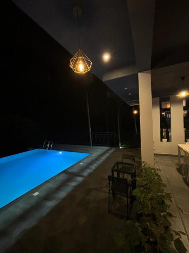 a swimming pool at night with a light fixture at Lush Hills by Benchmark in Kalpetta