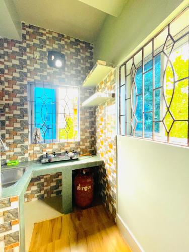 eine Küche mit Spüle und Buntglasfenstern in der Unterkunft Renade Leisure Stay in Agartala