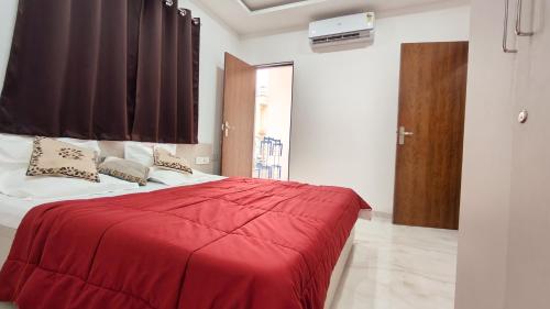 a bedroom with a red blanket on a bed at Staeg Mercury 1BHK -103 in Indore