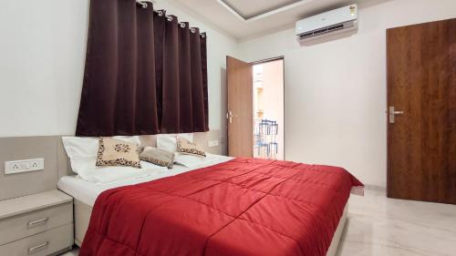a bedroom with a bed with a red blanket at Staeg Mercury 1BHK -103 in Indore