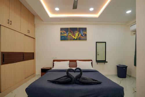 two black swans sitting on a bed in a room at N Cube Serviced Apartments in Hyderabad