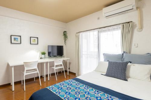 a bedroom with a bed and a desk and a television at Grande es TENJIN in Fukuoka