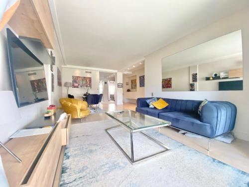 un salon avec un canapé bleu et une table en verre dans l'établissement Grand Hotel 2 chambres 2 sdb - GH, à Cannes