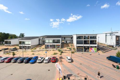 a parking lot with cars parked in front of a building at Hilmantori Apartments by Hiekka Booking in Kalajoki