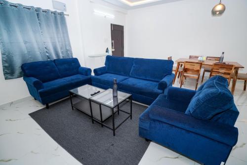 a living room with blue couches and a table at N Cube Serviced Apartments in Hyderabad