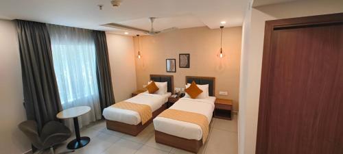 a hotel room with two beds and a window at HOTEL CHALLIYIL CASTLE in Shertallai