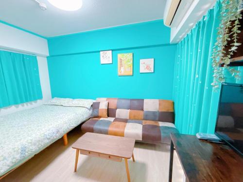 a bedroom with blue walls and a bed and a table at 403, Shinjuku Apt, Jr Yamanote Line, Jr山手线 高田馬場駅歩行5分 新宿 秋叶原 池袋 涩谷 六本木 上野直达 in Tokyo