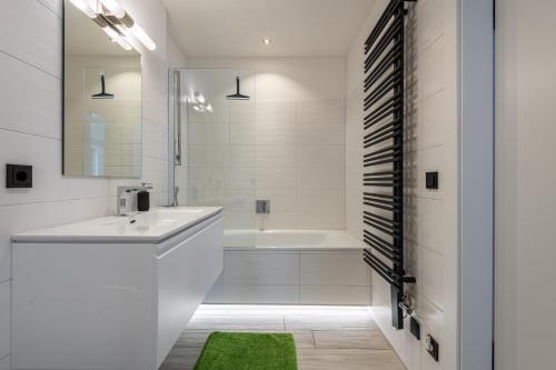 Baño blanco con bañera, lavabo y espejo en Haus Wieser en Kaprun