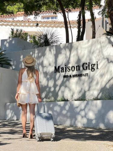 une femme en robe blanche tirant une valise dans l'établissement B&B Maison Gigi, à La Garde-Freinet