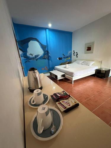 a hotel room with a bed and a table with plates at VitaminSea Room in Dauin