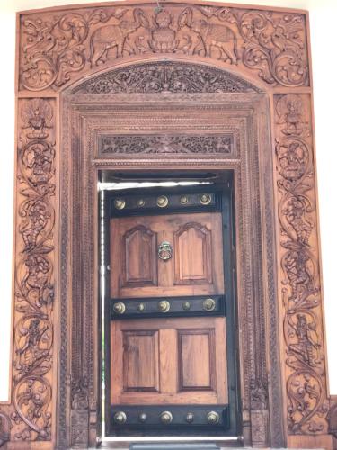an old wooden door in an ornate frame at The Windchimes Retreat Coorg in Virajpet