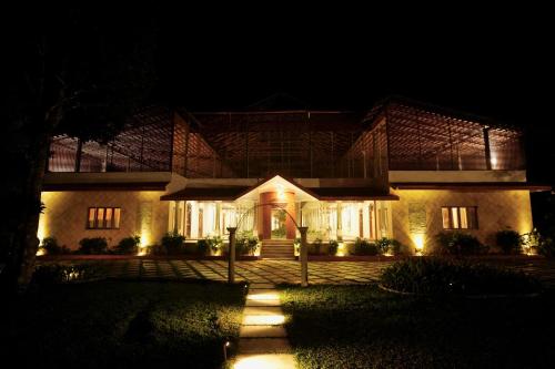 a house at night with lights in front of it at The Windchimes Retreat Coorg in Virajpet