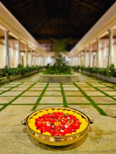 a bowl of red and yellow flowers in a building at The Windchimes Retreat Coorg in Virajpet