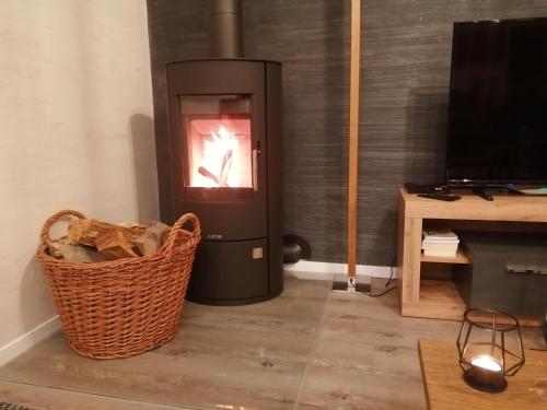 a living room with a heater and a basket at Fewo River I Familienfreundlich I großer Garten I inkl Badefass I Kamin I Spielplatz in Wendisch Rietz