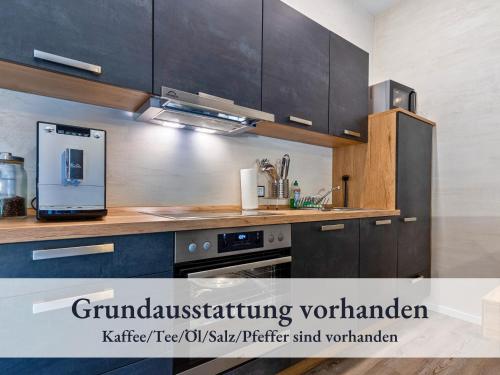 a kitchen with wooden cabinets and a stove top oven at Fewo River I Familienfreundlich I großer Garten I inkl Badefass I Kamin I Spielplatz in Wendisch Rietz