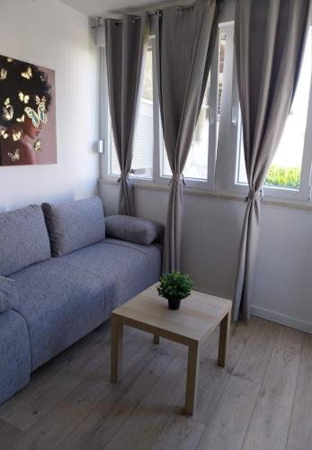 a living room with a blue couch and a table at Apartments Danijela in Tribunj