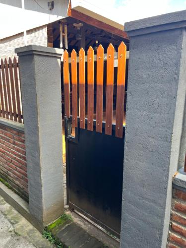 a black gate with an orange fence in front of a house at Gemyah in Banyuwangi