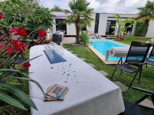 - une table munie d'une pancarte à côté de la piscine dans l'établissement Villa plage piscine chauffée, à La Bernerie-en-Retz