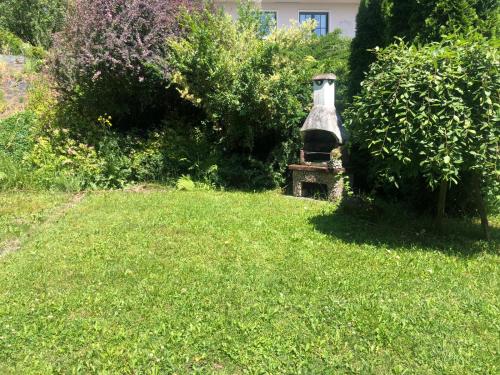 a bell sitting in the middle of a grass field at Noclegi Bajama in Siepraw