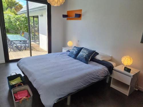 une chambre avec un grand lit et un patio dans l'établissement Villa plage piscine chauffée, à La Bernerie-en-Retz