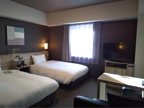 Hotel Route-Inn Mihara Ekimae في ميهارا: غرفه فندقيه سريرين وتلفزيون
