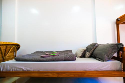a bed with three pillows on top of it at Hangout Haven Siargao Homestay in Dapa