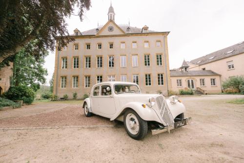an old white car parked in front of a building at Hôtel Château Schengen in Schengen