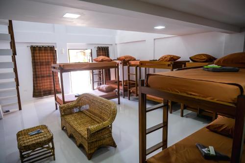 a room with several bunk beds and a chair at Hangout Haven Siargao Homestay in Dapa