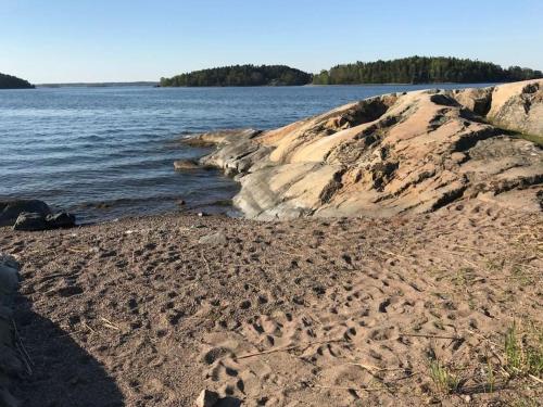 a sandy beach next to a body of water at Vaxholm Skarpö archipelago island living with car access in Vaxholm