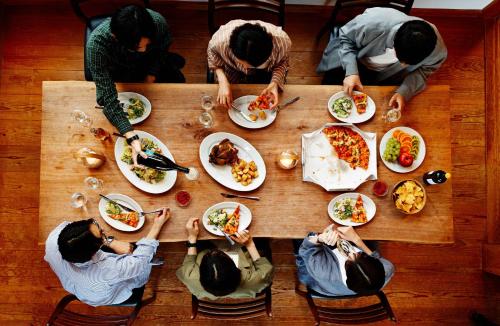 a group of people sitting around a table eating food at Suite Villa Ocean View Atami Shizenkyo in Atami