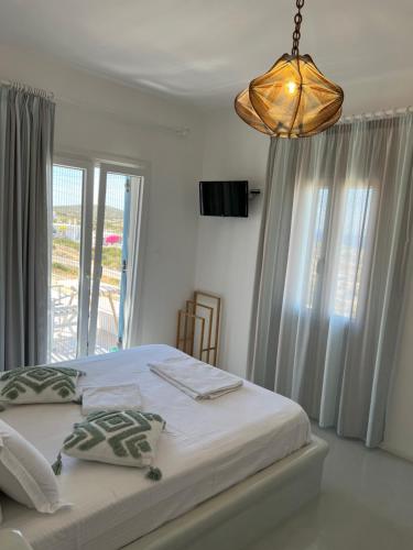 a bedroom with a bed and a chandelier at Alexandra’s studios in Iraklia