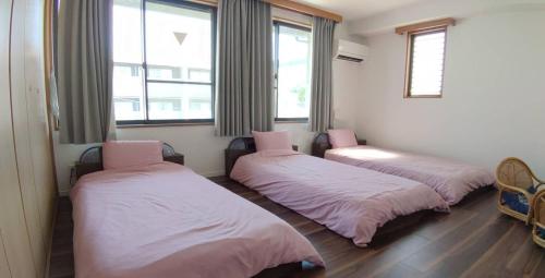 three beds sitting in a room with windows at Kyoto Guesthouse Rantan - Vacation STAY 84841v in Nishi-kujō-Toriiguchichō