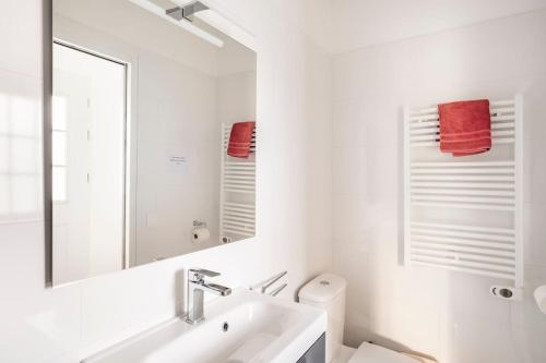 une salle de bain blanche avec un lavabo et un miroir dans l'établissement sublime appart terrasse piscine privee jardin, à Aubagne