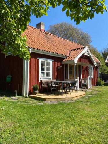 ein rotes Haus mit einem Picknicktisch davor in der Unterkunft Bo i egen stuga på härlig ölandsgård in Köpingsvik