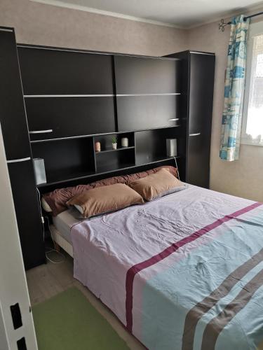 une chambre avec un grand lit avec une tête de lit noire dans l'établissement Vacances au Cap d Agde, au Cap d'Agde