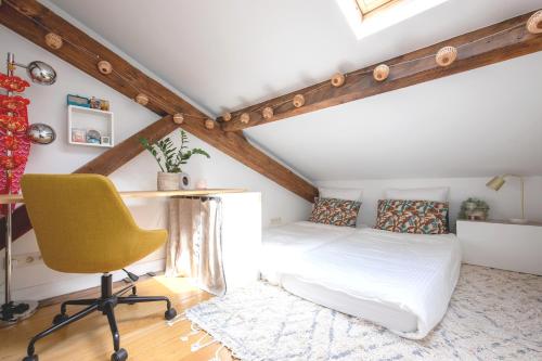 une chambre avec un lit, un bureau et une chaise dans l'établissement Luxury top floor duplex near Le Marais, à Paris