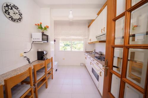 a kitchen with white cabinets and a counter top at Antoxos Sacra Home I in Chantada