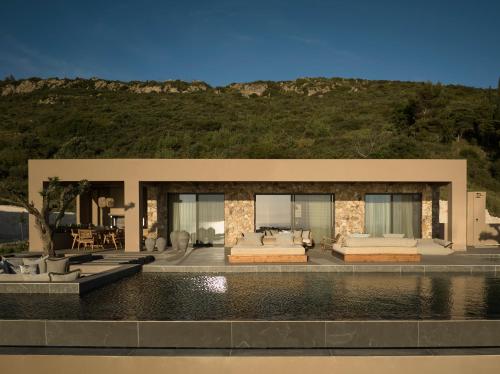 a house with a pool in front of it at Memorias Suites and Villa in Vasilikos