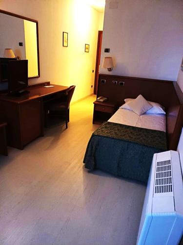 a hotel room with a bed and a desk at Hotel In Sylvis in Sesto al Reghena