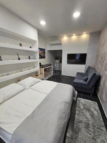 a bedroom with a large bed and a chair at Ellamar City Center Apartment in Makarska