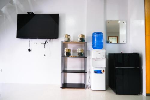 a living room with a tv and a refrigerator at Hangout Haven Siargao Homestay in Dapa