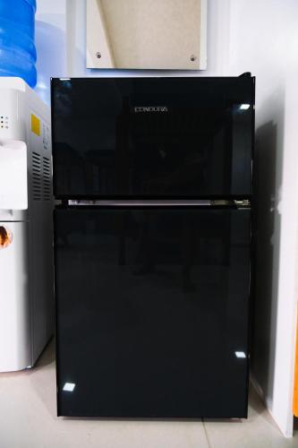 a black microwave oven sitting on top of a refrigerator at Hangout Haven Siargao Homestay in Dapa